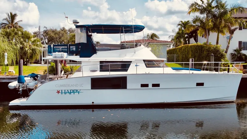 Slide: The Image of 2015 Fountaine Pajot Cumberland 47 LC yacht docked by palm trees. - 0