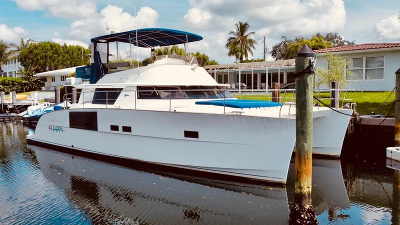 Slide: The Image of 2015 Fountaine Pajot Cumberland 47 LC yacht docked in a serene marina setting. - 10
