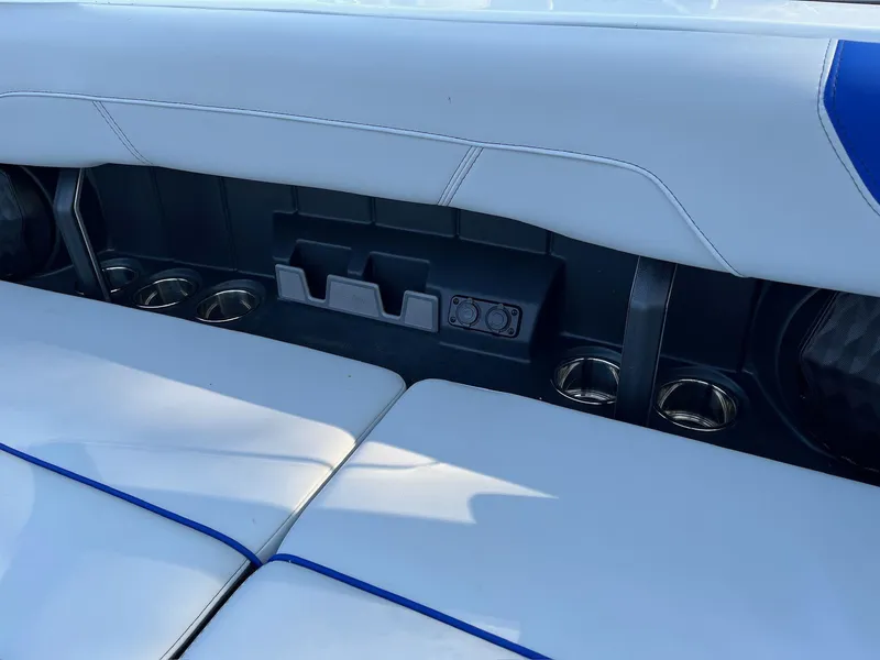 Slide: The Image of 2024 Malibu 20VTX boat interior with white seating and cup holders. - 13