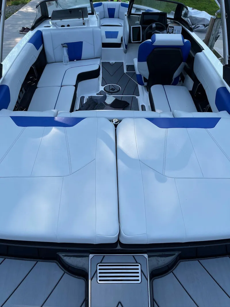 Slide: The Image of 2024 Malibu 20VTX boat interior with white and blue seating, modern dashboard, and spacious layout. - 4