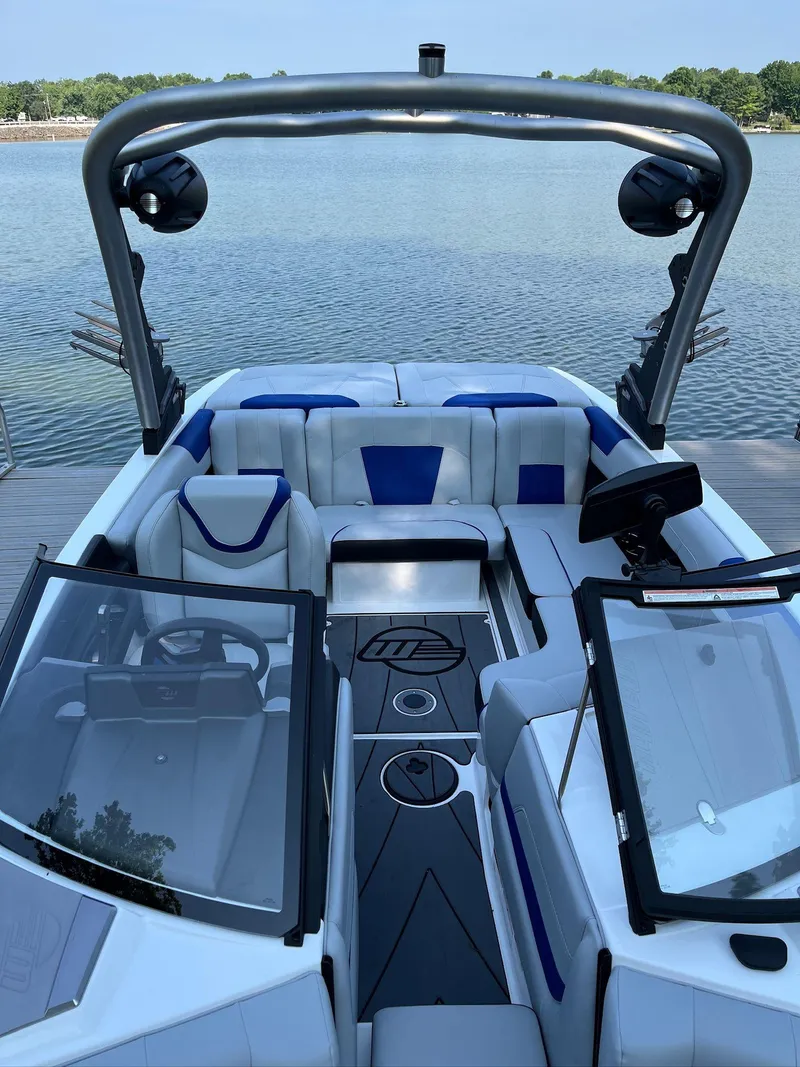 Slide: The Image of 2024 Malibu 20VTX boat interior with sleek design and modern features on a calm lake. - 7