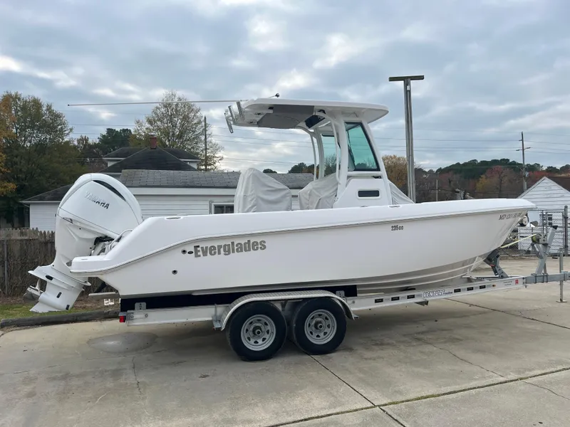 Slide: The Image of 2022 Everglades 235 Center Console boat on trailer, parked outdoors. - 0