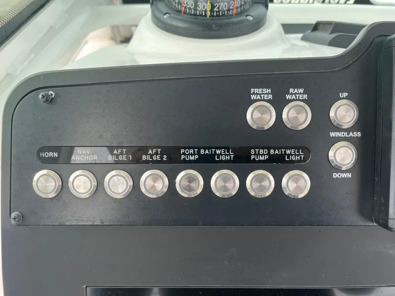 Slide: The Image of Control panel of 2022 Everglades 235 Center Console boat with various switches and compass. - 15