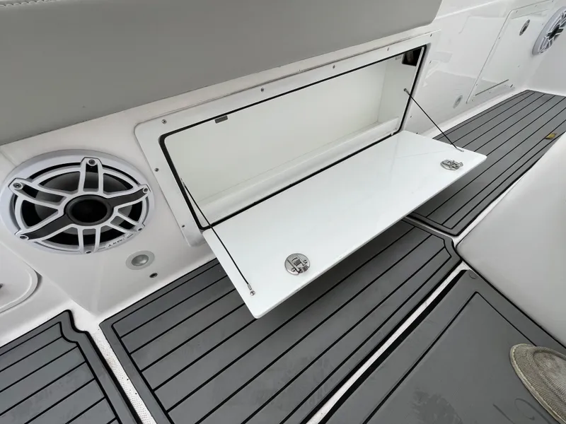 Slide: The Image of 2022 Everglades 235 Center Console storage compartment with speaker and non-slip flooring. - 19