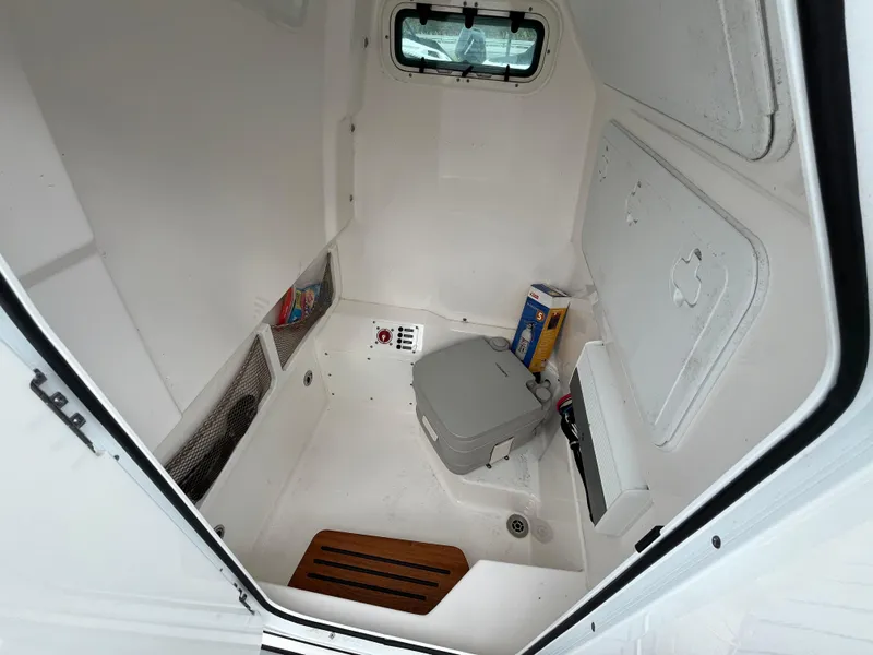 Slide: The Image of Interior of 2022 Everglades 235 Center Console boat with compact toilet and storage. - 21
