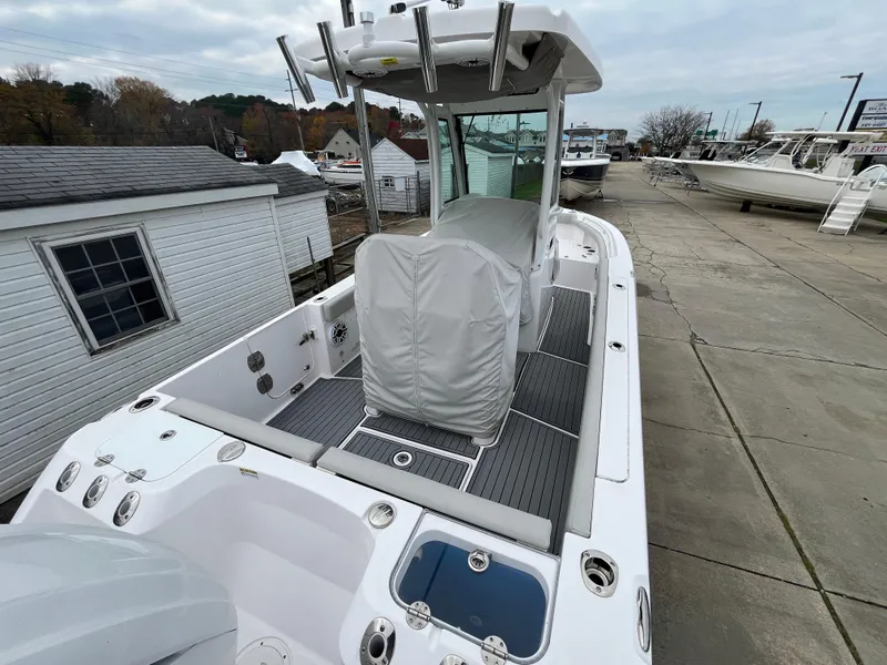 Slide: The Image of 2022 Everglades 235 Center Console boat with covered seating, docked outdoors. - 6