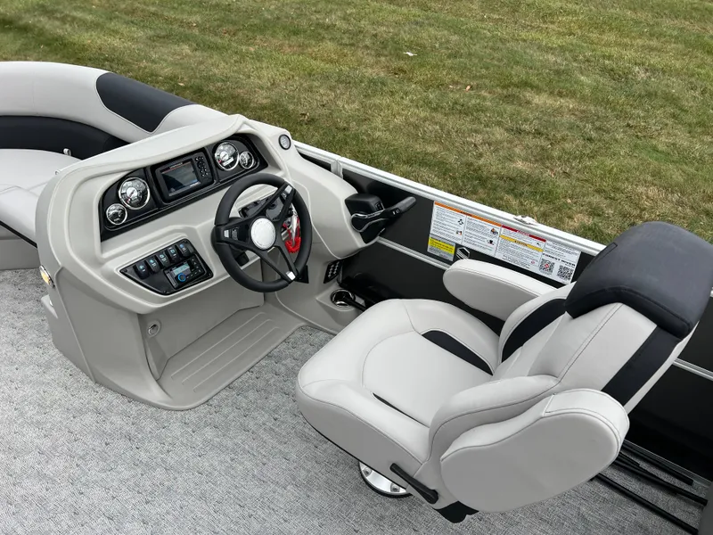 Slide: The Image of 2025 South Bay 222 RS LE boat interior with steering console and plush seating. - 18