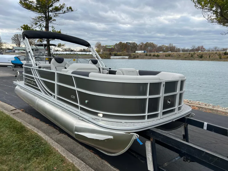 Slide: The Image of 2025 South Bay 222 RS LE pontoon boat on trailer by a lake. - 3