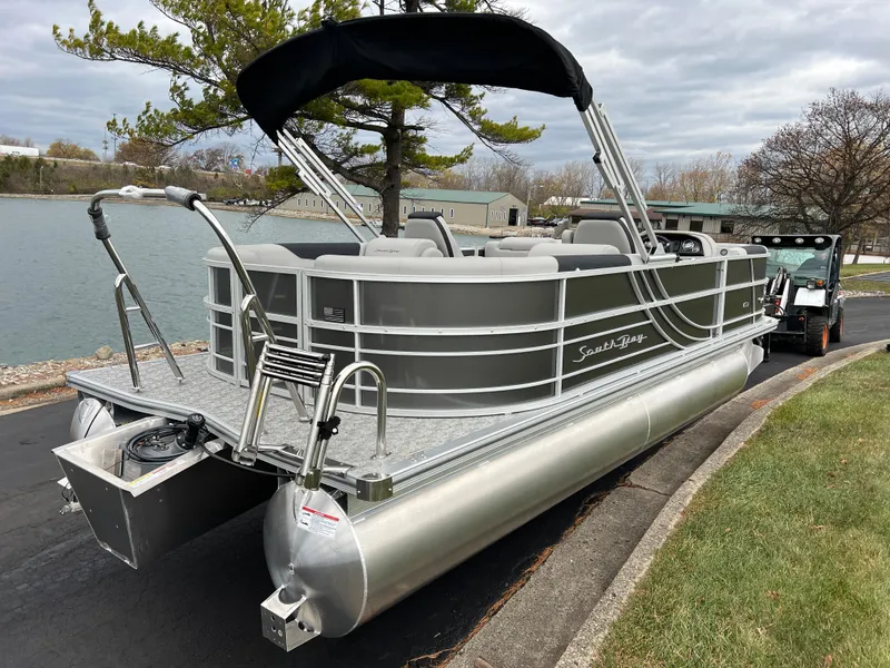 Slide: The Image of 2025 South Bay 222 RS LE pontoon boat parked by a lakeside. - 5