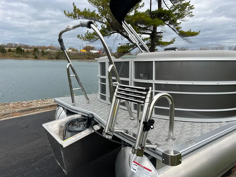 Slide: The Image of 2025 South Bay 222 RS LE pontoon boat docked by a scenic lake. - 7