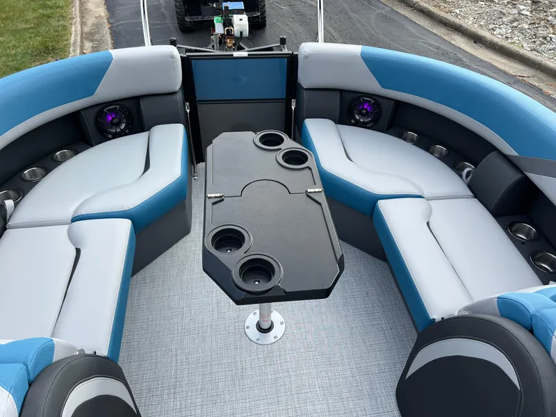Slide: The Image of 2025 South Bay SS222 RS boat interior with blue and gray seating and a central table. - 18