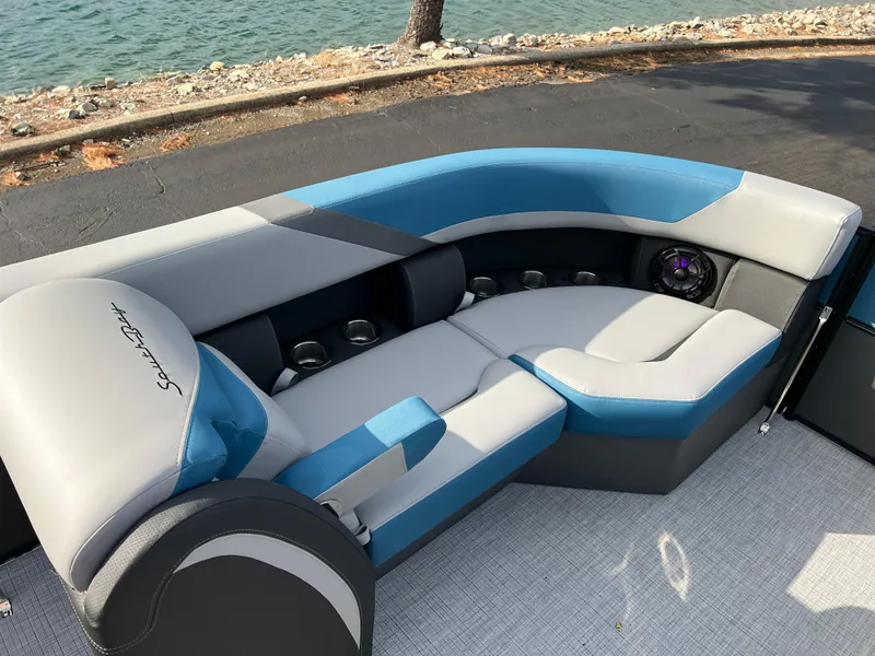 Slide: The Image of 2025 South Bay SS222 RS boat interior with blue and gray seating by the water. - 27