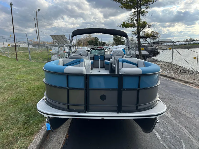 Slide: The Image of 2025 South Bay SS222 RS pontoon boat, blue and gray, parked near a marina. - 3