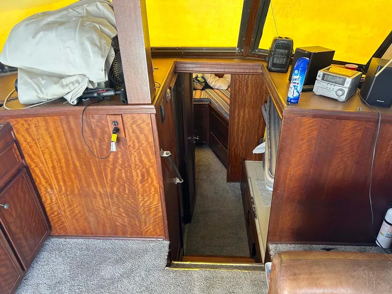 Slide: The Image of Interior of a 1975 Hatteras 36 Convertible boat with wood paneling and carpeted flooring. - 16
