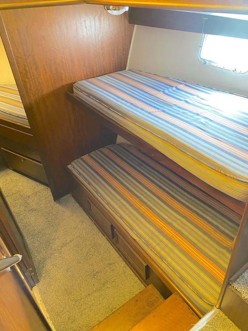 Slide: The Image of 1975 Hatteras 36 Convertible cabin with striped bunk beds and wooden interior. - 18