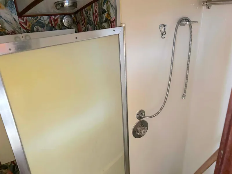 Slide: The Image of 1975 Hatteras 36 Convertible yacht shower with floral wallpaper and handheld showerhead. - 20