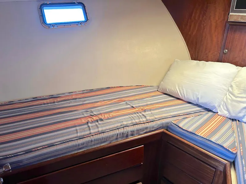 Slide: The Image of Cozy cabin interior of 1975 Hatteras 36 Convertible with striped bedding. - 24