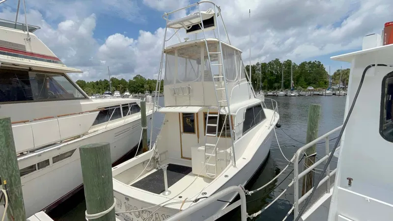 Slide: The Image of 1975 Hatteras 36 Convertible yacht docked at marina under cloudy sky. - 3
