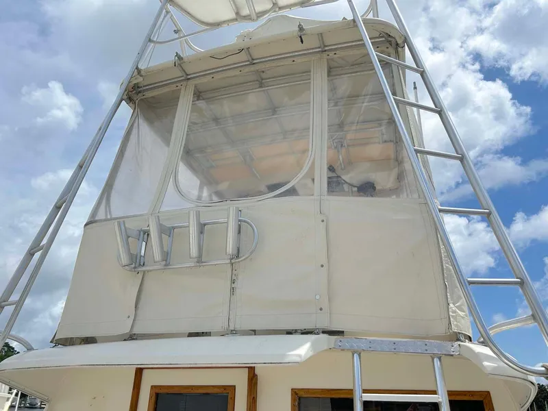 Slide: The Image of 1975 Hatteras 36 Convertible boat with enclosed flybridge and ladder under a cloudy sky. - 34