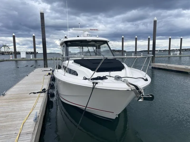 Slide: The Image of 2023 Boston Whaler 325 Conquest docked at marina under cloudy skies. - 4