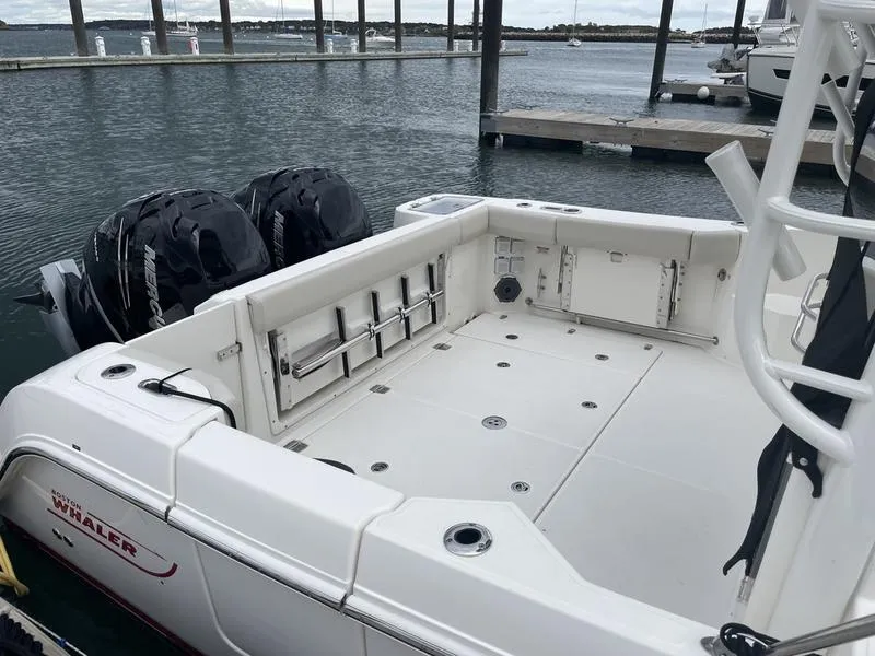 Slide: The Image of 2023 Boston Whaler 325 Conquest boat docked, featuring spacious deck and dual engines. - 5