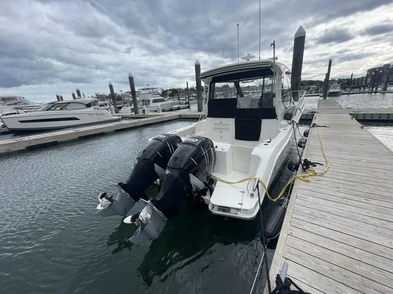 Slide: The Image of 2023 Boston Whaler 325 Conquest docked with dual outboard engines. - 7
