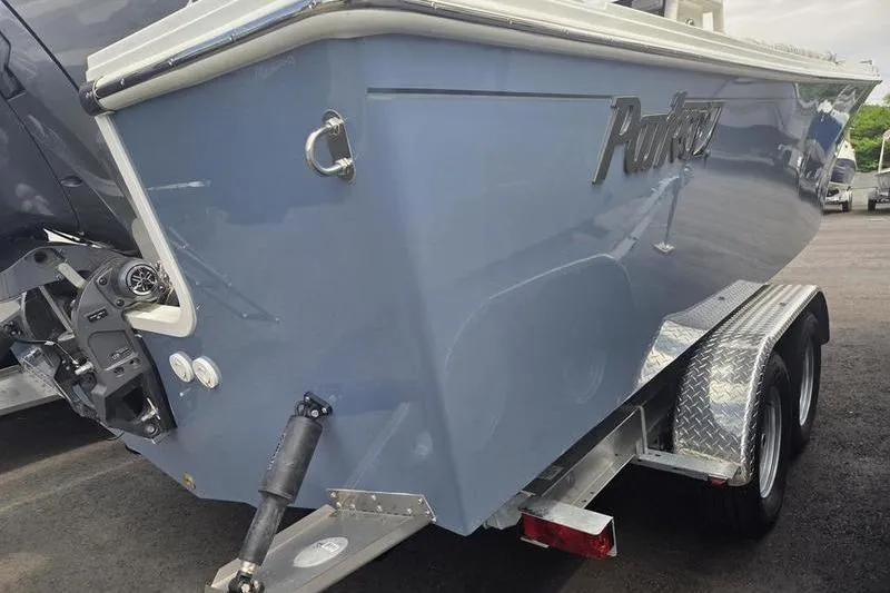 Slide: The Image of 2025 Parker 23 SE CC boat on trailer, rear view, blue hull. - 10