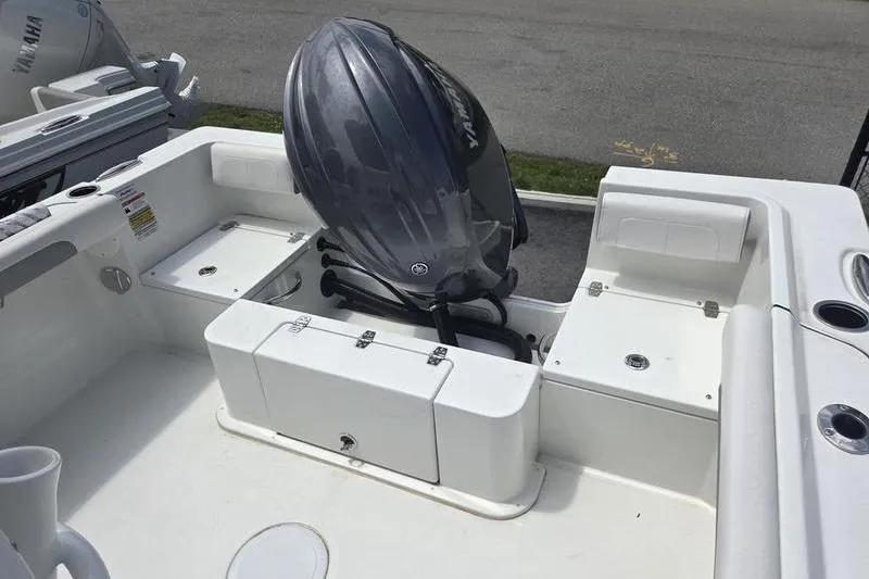 Slide: The Image of 2025 Parker 23 SE CC boat with Yamaha outboard motor, white deck, and storage compartments. - 12
