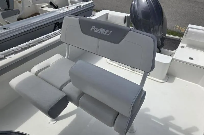 Slide: The Image of 2025 Parker 23 SE CC boat interior with cushioned seating and motor. - 14