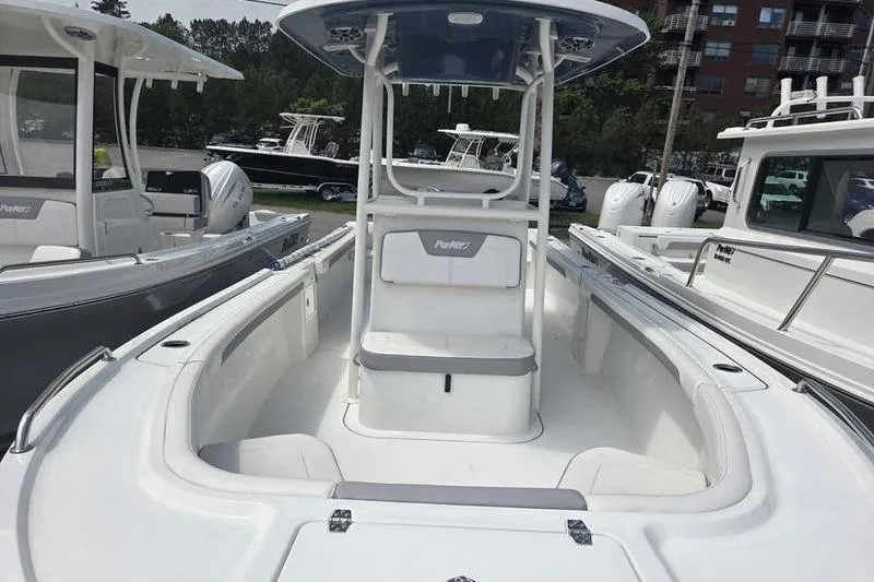 Slide: The Image of 2025 Parker 23 SE CC boat with center console and seating, docked among other boats. - 4