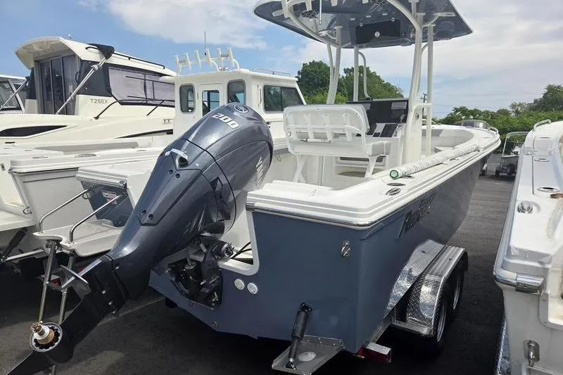 Slide: The Image of 2025 Parker 23 SE CC boat with outboard motor, parked on a trailer. - 5