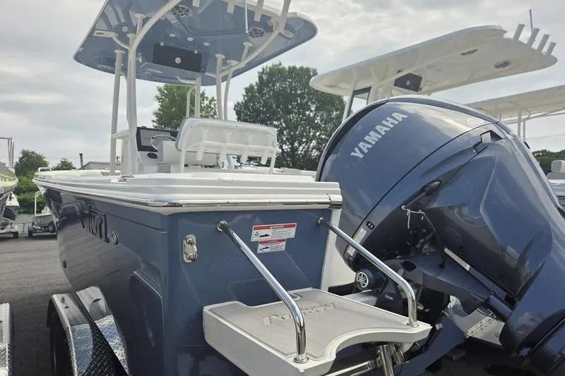 Slide: The Image of 2025 Parker 23 SE CC boat with Yamaha engine, parked outdoors. - 7