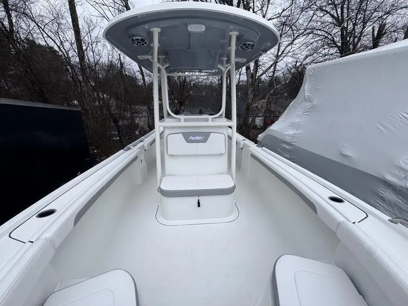 Slide: The Image of 2025 Parker 23 SE CC boat with T-top, white interior, and seating, docked outdoors. - 3