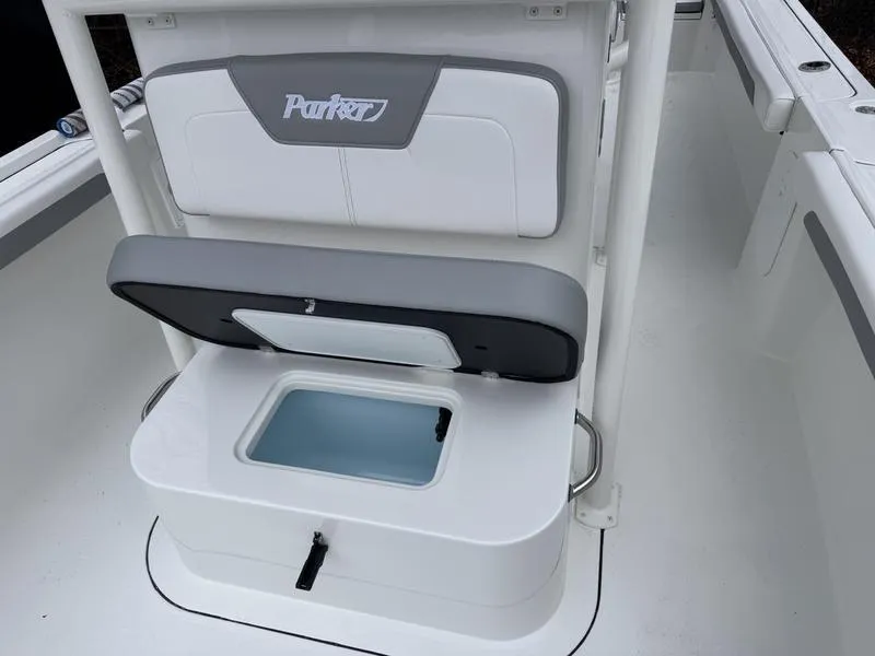 Slide: The Image of 2025 Parker 23 SE CC boat with open storage compartment and cushioned seating. - 8