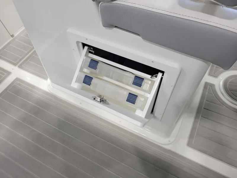 Slide: The Image of Storage compartment on 2025 Parker 2200 CC boat with sliding trays and gray flooring. - 12