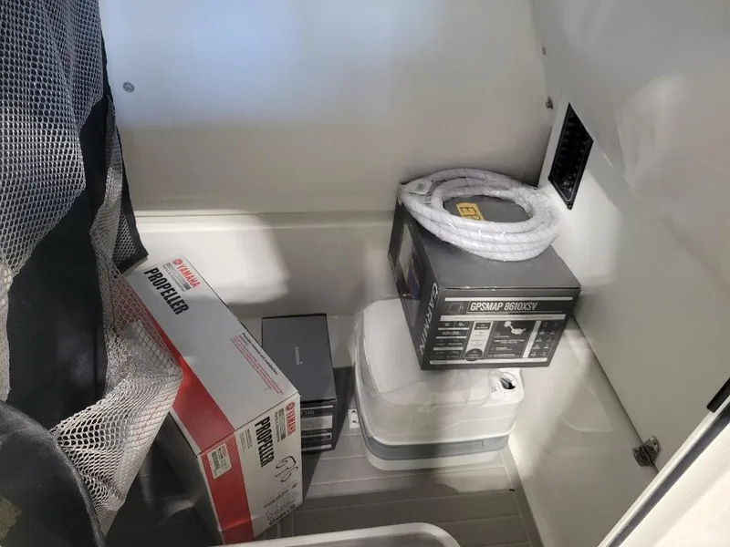 Slide: The Image of Storage compartment in a 2025 Parker 2200 CC boat with various equipment and supplies. - 20