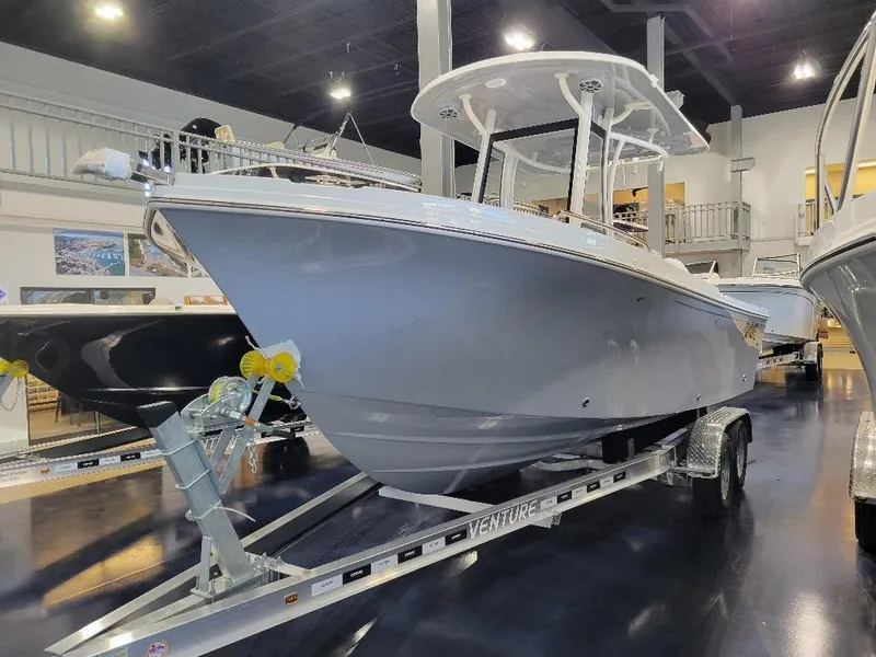 Slide: The Image of 2025 Parker 2200 CC boat on trailer in showroom, sleek design, modern features. - 4