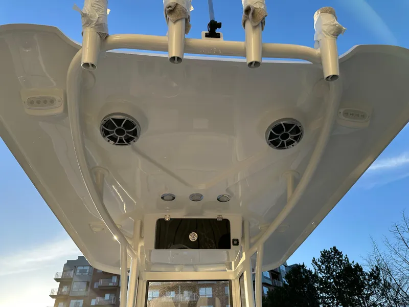 Slide: The Image of 2025 Parker 2200 CC boat's overhead view with speakers and rod holders against blue sky. - 10