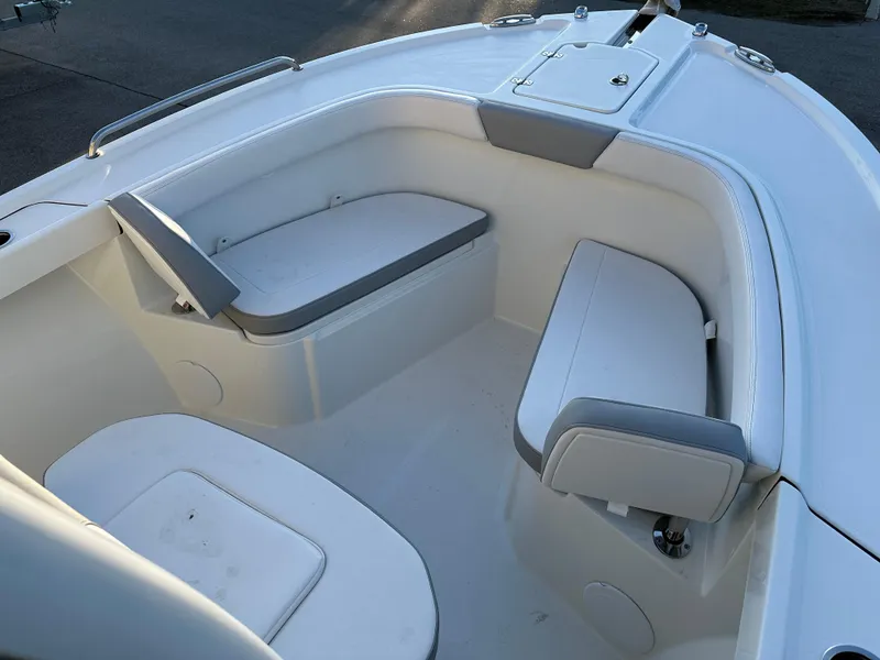 Slide: The Image of 2025 Parker 2200 CC boat interior with cushioned seating and storage compartments. - 18