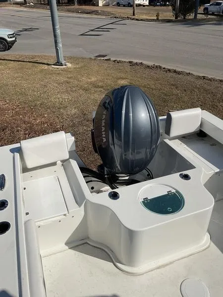 Slide: The Image of Parker 2120 Sport Cabin 2025 boat with Yamaha outboard motor, parked on grass. - 10