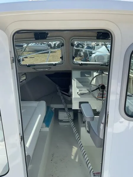 Slide: The Image of Interior of 2025 Parker 2120 Sport Cabin boat, featuring steering wheel and seating. - 3