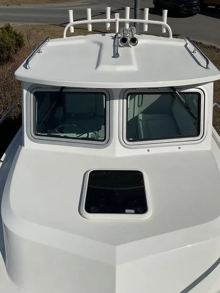 Slide: The Image of 2025 Parker 2120 Sport Cabin boat, white exterior, front view with windows and hatch. - 5