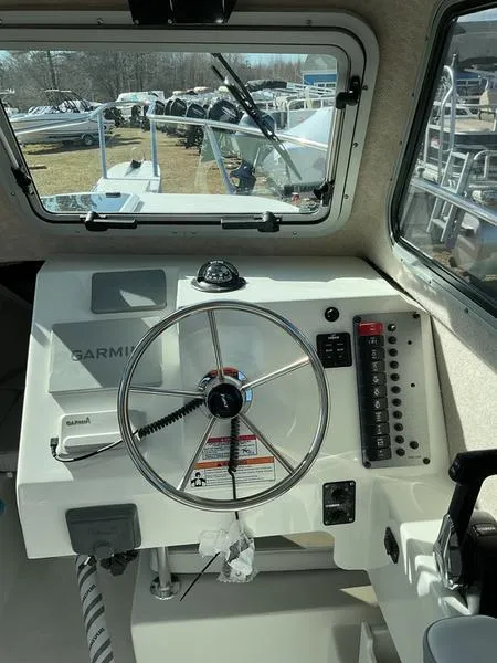 Slide: The Image of Interior view of 2025 Parker 2120 Sport Cabin boat dashboard with steering wheel and controls. - 6