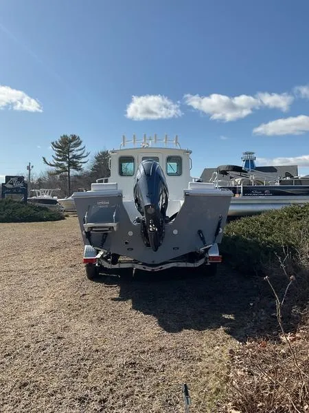 Slide: The Image of 2025 Parker 2120 Sport Cabin boat on display under clear blue sky. - 7