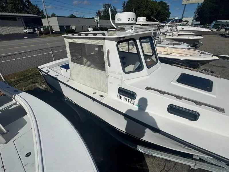 Slide: The Image of 1996 Eastern 27 Lobster Fisherman boat in a marina, white exterior, side view. - 15