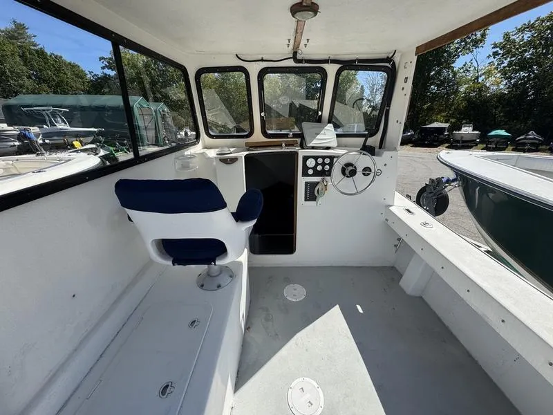 Slide: The Image of 1996 Eastern 27 Lobster Fisherman boat interior with steering wheel and seating. - 4