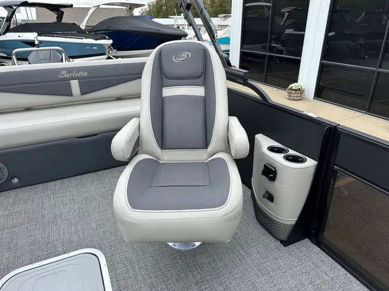 Slide: The Image of Barletta C24UC 2025 boat interior with gray captain's chair and cup holders. - 14
