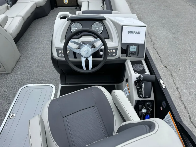 Slide: The Image of 2025 Barletta C24UC boat cockpit with steering wheel and Simrad display. - 17