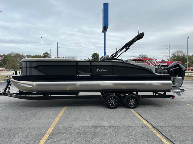 Slide: The Image of 2025 Barletta C24UC pontoon boat on trailer in parking lot. - 6
