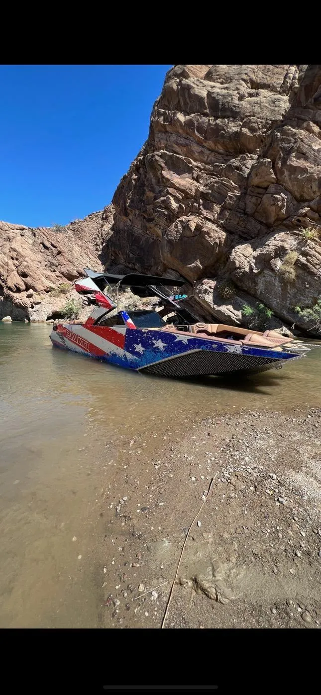 Slide: The Image of 2022 Pavati AL26 boat with patriotic design in a rocky canyon setting. - 3